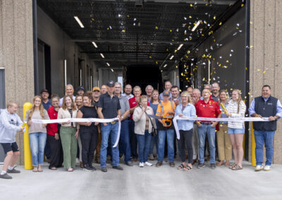 Confetti falls as Woody's Trucking celebrates the ribbon cutting for their building expansion