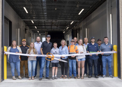 Woody's Trucking team and guests gathered in the new wash-bay for the ribbon-cutting ceremony